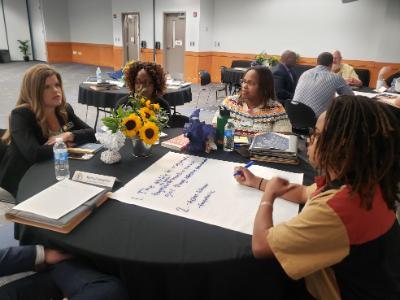 PLI Cohort members having a discussion at a round table. 